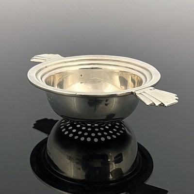Lot 123 - An Art Deco silver tea strainer, Barker...