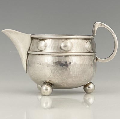 Lot 140 - A George V Arts and Crafts silver cream or...
