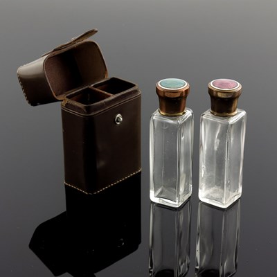 Lot 598 - A cased set of enamel lidded glass bottles,...
