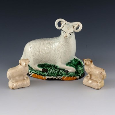Lot 1115 - A Staffordshire pottery ram and two white...