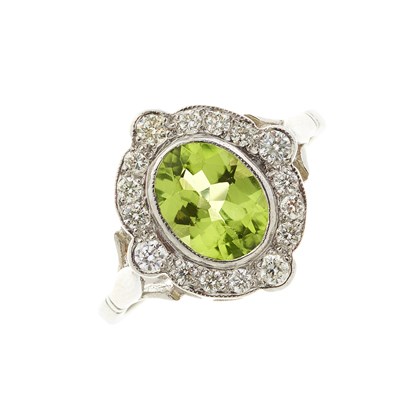 Lot 78 - A platinum peridot and diamond cluster dress ring