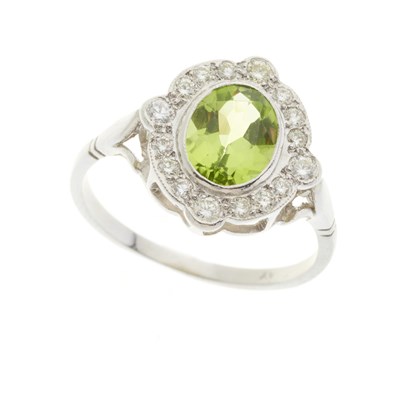 Lot 78 - A platinum peridot and diamond cluster dress ring