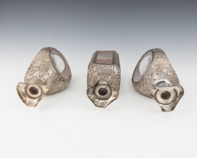 Lot 30 - China. Three Chinese silver overlay decanters,...