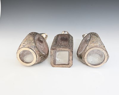 Lot 30 - China. Three Chinese silver overlay decanters,...