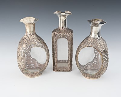 Lot 30 - China. Three Chinese silver overlay decanters,...