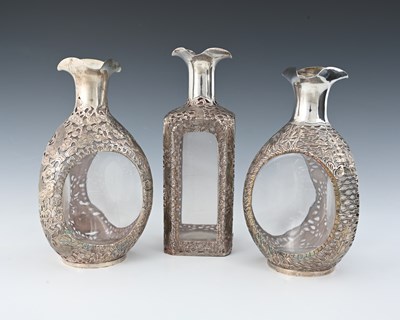 Lot 30 - China. Three Chinese silver overlay decanters,...