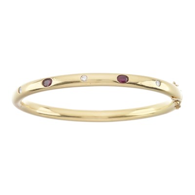Lot 55 - An 18ct gold ruby and diamond bangle bracelet
