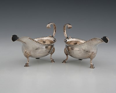 Lot 349 - A pair of George III silver sauce boats, atop...