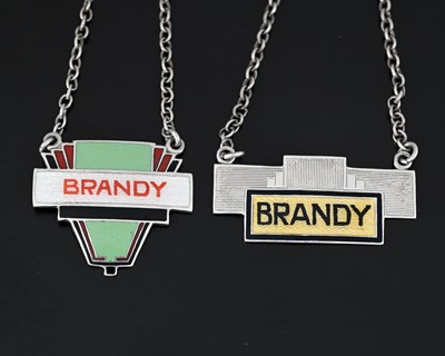 Lot 581 - Two Art Deco silver and enamel wine labels,...