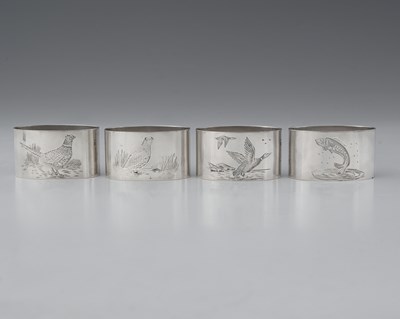Lot 513 - A set of four silver napkin rings, decorated...