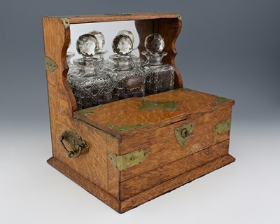 Lot 224 - An Edwardian oak triple tantalus, brass mounts...