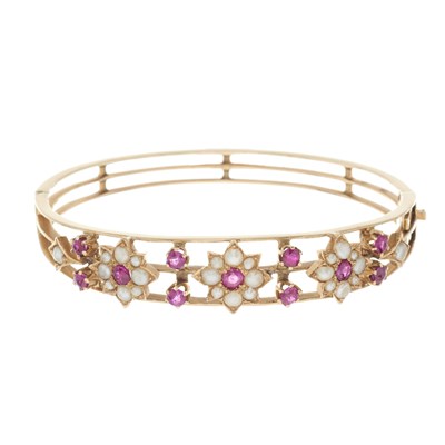 Lot 26 - An early 20th century ruby and split pearl floral bangle bracelet