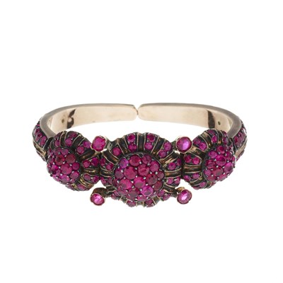 Lot 101 - A ruby triple cluster panel sprung torque bangle