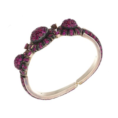 Lot 101 - A ruby triple cluster panel sprung torque bangle