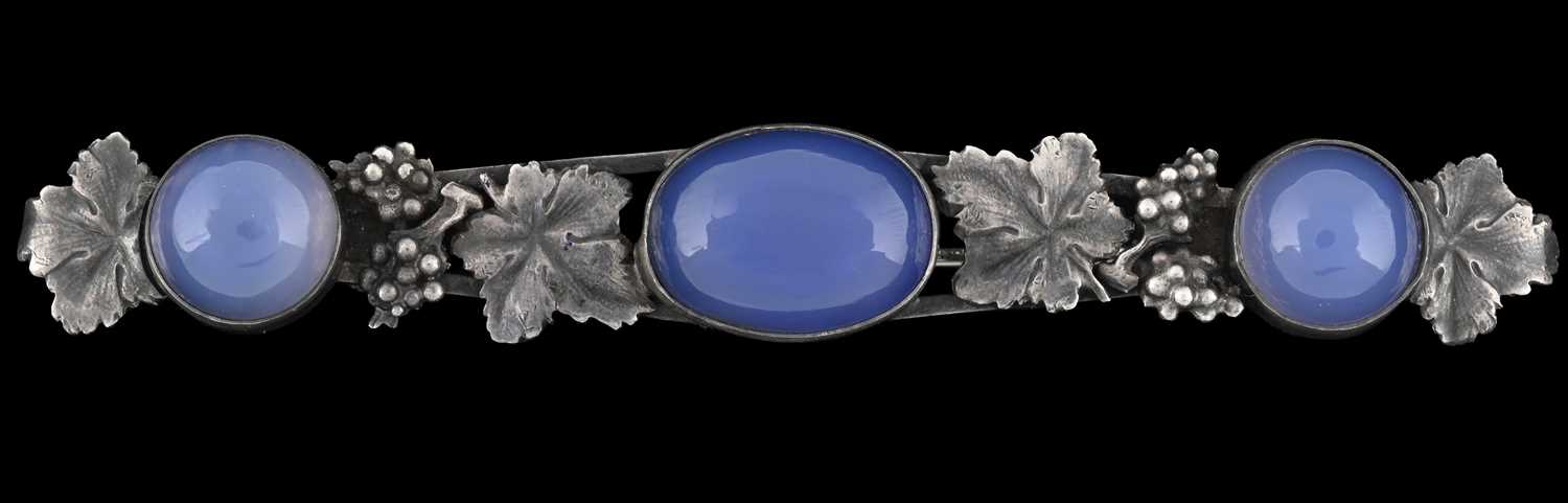 Lot 15 - An Arts & Crafts silver blue chalcedony brooch, with bunches of grapes and leaf detail
