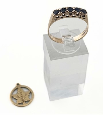 Lot 453 - A 9ct gold sapphire five stone ring and a leaf charm