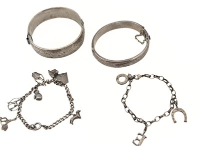 Lot 552 - Two silver hinged bangles and two charm bracelets