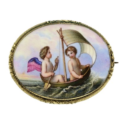 Lot 478 - A Victorian hand painted ceramic brooch, depicting putti in a sale boat