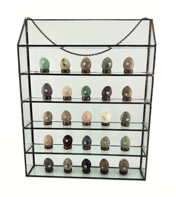 Lot 343 - A selection of gem stone eggs with glass display stand