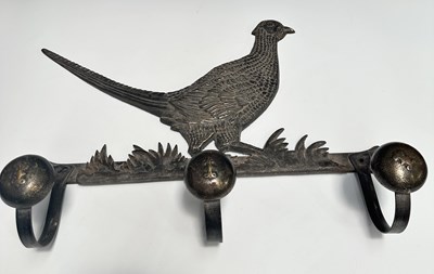 Lot 211 - A cast metal hat/apron rack in an aged brass...