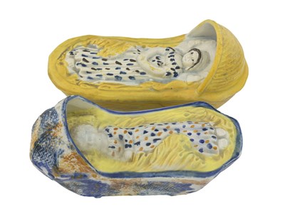 Lot 781 - Two Prattware models of cribs with infants,...