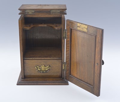 Lot 616 - An Arts & Crafts oak smoker's companion, circa...