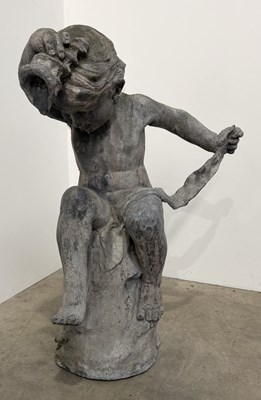 Lot 837 - A lead statue of a cherub/putti, seated on a...
