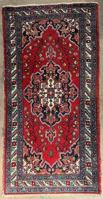 Lot 706 - A 20th century Persian wool rug, red field...