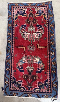 Lot 709 - A wool rug, peacocks and medallions on a red...