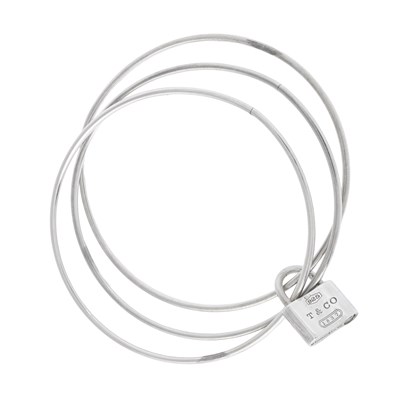 Lot 578 - Tiffany & Co., an 1837 triple bangle and removable padlock charm.