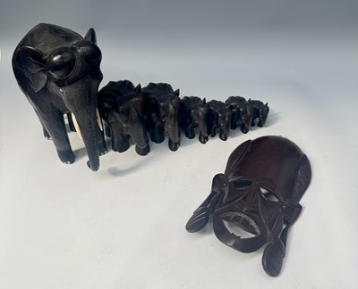 Lot 284 - A graduated set of seven carved hardwood...