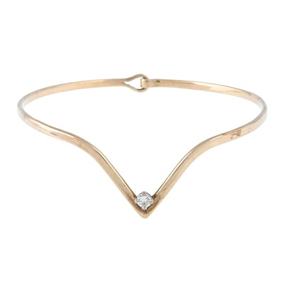 Lot 104 - A 9ct gold brilliant-cut diamond V-shape bangle