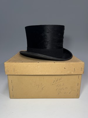 Lot 155 - A Moss Bros black silk top hat with felt band,...