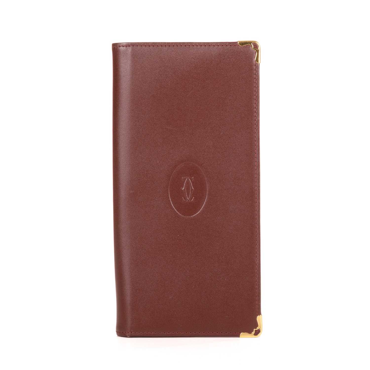 Lot 290 - Cartier, a long Bordeaux Bifold wallet,...