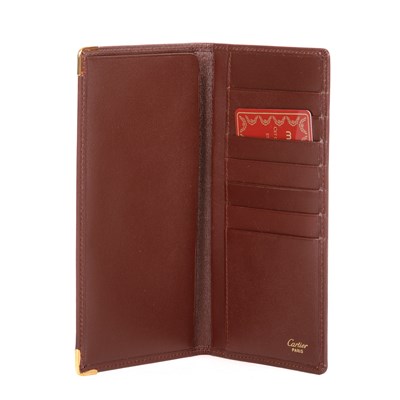 Lot 292 - Cartier, a long Bordeaux Bifold wallet,...